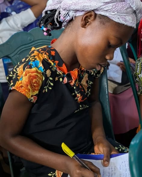 A young participant taking notes at the 2025 Forum